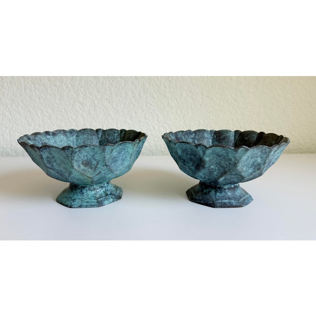 A rare pair of cast bronze footed bowls with verdigris finish. Features a diamond or faceted design around the perimeter...