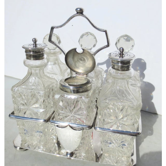 Six set cruet set with cut faceted bottles and faceted stoppers. Circa 1880 with shield crest. Silver-plated caddy....