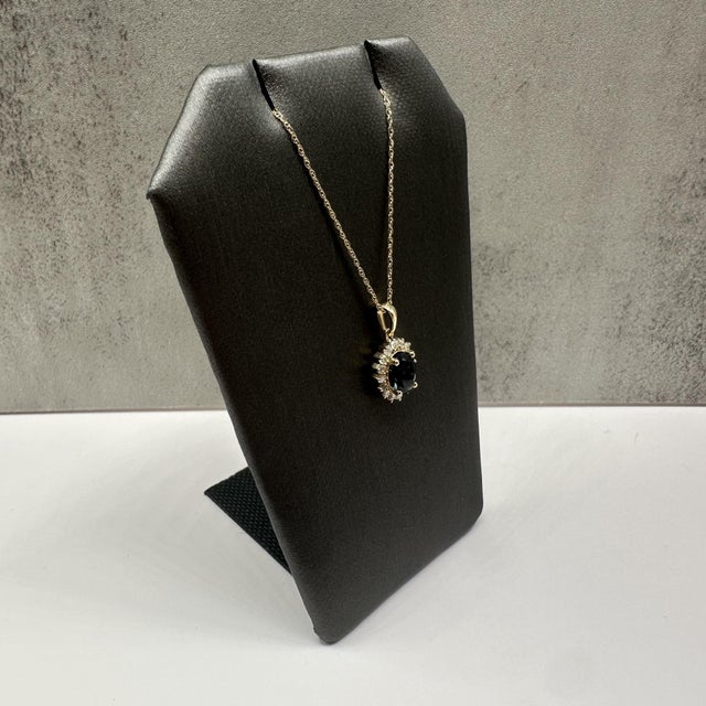 This elegant topaz and diamond necklace in 10kt yellow gold features a rich oval cut London blue topaz measuring...