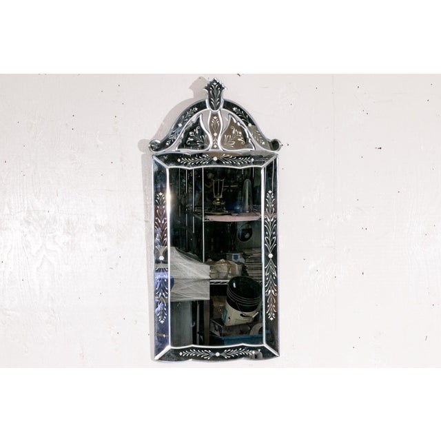 A decorative early 20th century Venetian style tall wall mirror with an arched pediment, decorative finial and elaborate...