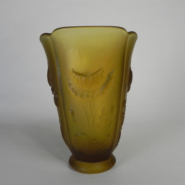 Pressed glass vase from Bohemia, made of matte amber glass and featuring a relief decoration of four different flowers....