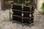 An English ebonized three-tiered freestanding shelf from the turn of the century, with chinoiserie decor and gilded...