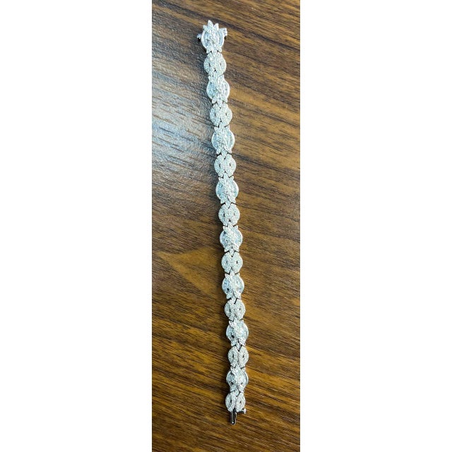 Elegantly crafted, this exquisite bracelet showcases a series of intricately designed floral motifs, each adorned with...