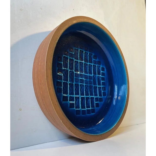A rare dish or bowl by the danish ceramist jørgen mogensen. Unglazed stoneware exterior and an interior with abstract...