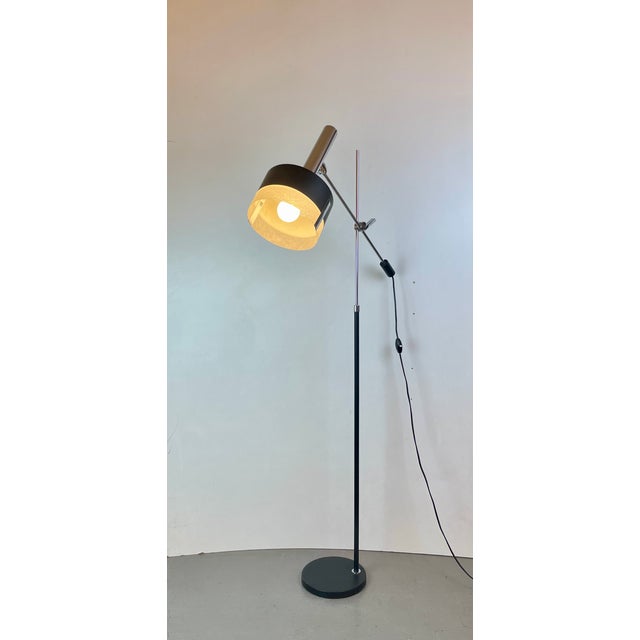 Stunning floor lamp made of black lacquered metal, chromed steel, and a textured resin diffuser. this fully adjustable...