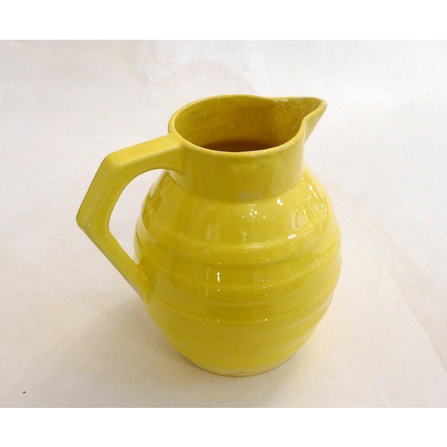 Large 1950s Art Deco style pitcher, with a bulbous, oval body featuring raised, ringed details and a stylized geometric...