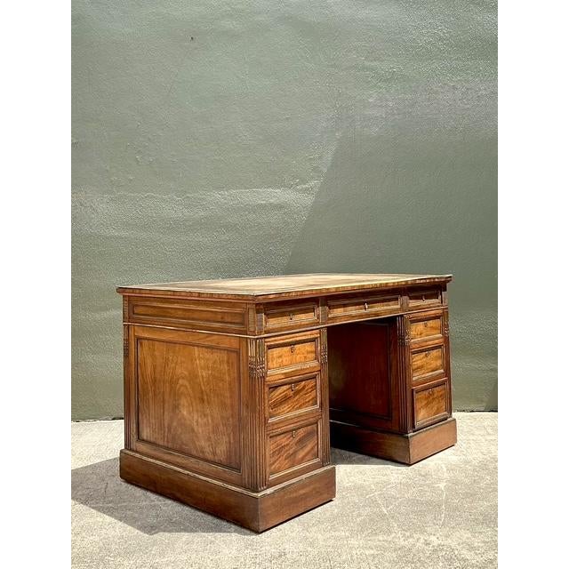 Experience the pinnacle of British cabinetmaking with this exquisite pedestal desk by the renowned London makers, Bertram...