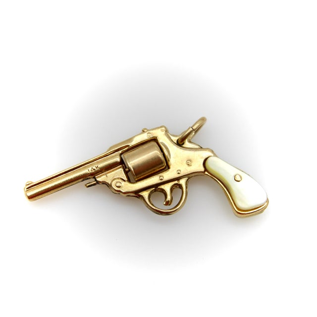 This highly collectable vintage 14k gold pendant is a miniature replica of a (non-working) gun. It has sweet, carved...