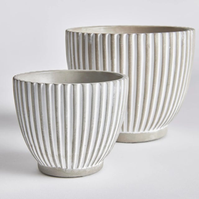 A simple pattern of vertical lines make this set of tapered pots very mod indeed. A translucent white wash artfully fills...