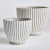 A simple pattern of vertical lines make this set of tapered pots very mod indeed. A translucent white wash artfully fills...