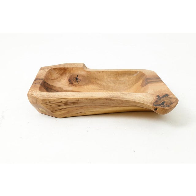 Carved from a single piece of wood, this hand-worked basin is a functional sculpture that brings a raw, elemental presence...