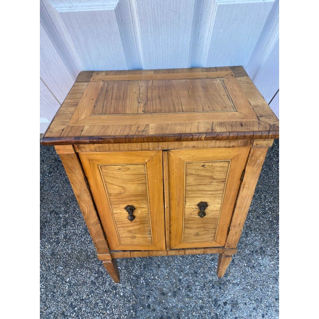Neoclassical Stand. Olivewood and Fruitwood Veneers retaining there original patina. One interior shelf Southern European...