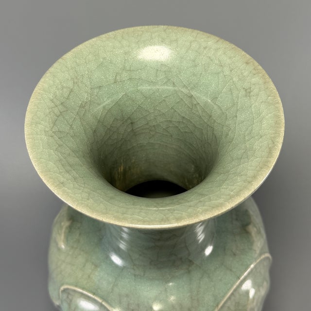 Fine antique Chinese celadon flared‑rim vase. Wide flaring opening with tall neck, body decorated with raised floral...