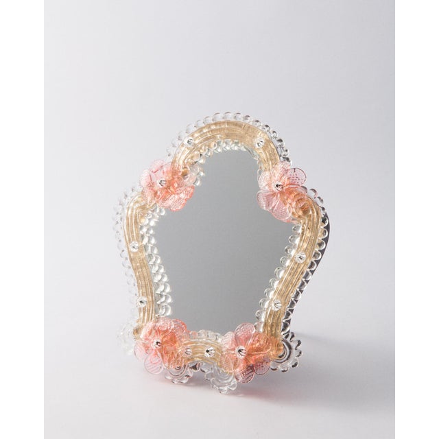 This Murano glass mirror is handcrafted in Venice by a centuries-old atelier known for its masterful ornamentation. A...