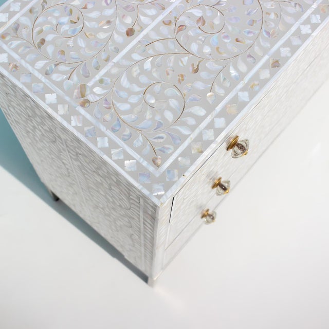 The Arabesque Mother of Pearl Inlay Three-Drawer Dresser celebrates the elegance of classical botanical ornamentation...