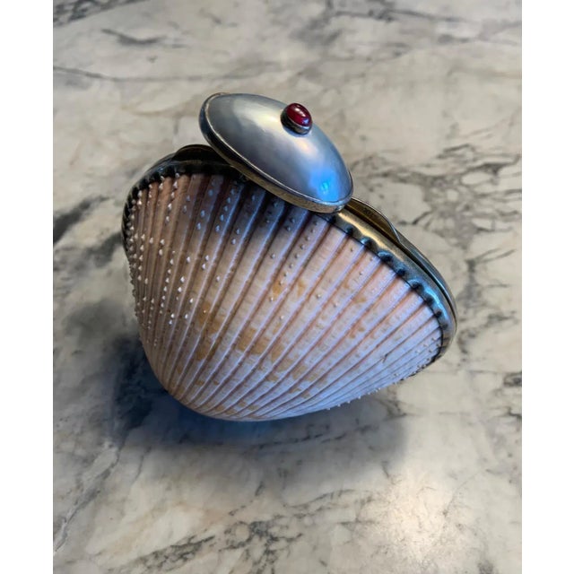 This rare shell minaudiere from Marguerite Stix has a ruby cabochon and large blister pearl for the clasp and a gold...