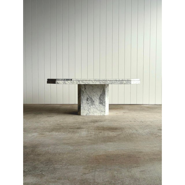This 1970s vintage marble square coffee table features a bold geometric inlaid top composed of contrasting Carrara and...