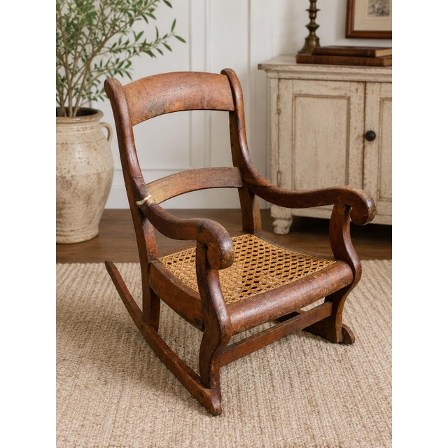 This beautifully aged child’s rocking chair embodies the timeless craftsmanship of American furniture from the turn of the...