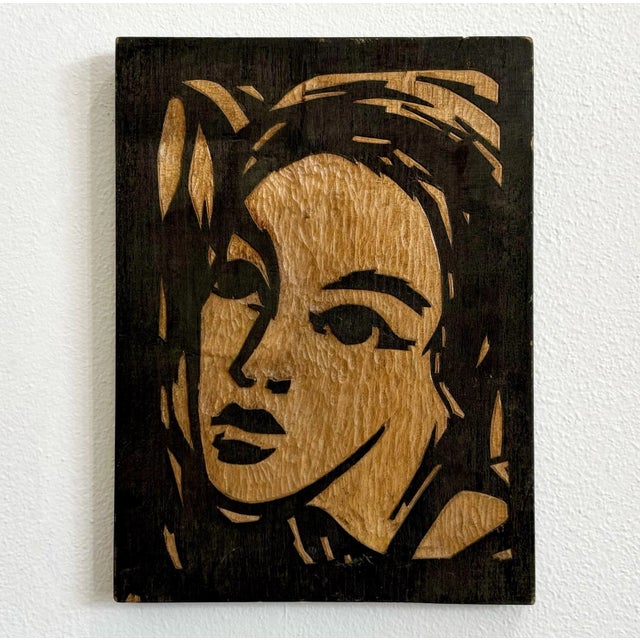 This woodcut-style portrait radiates bold attitude and graphic allure, carved with sharp contrast and expressive...