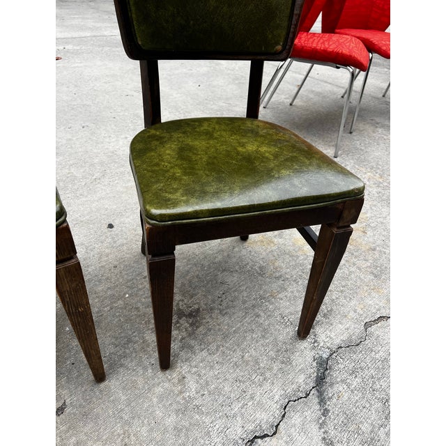 Up for consideration is a beautiful vintage collection of green leather gun lock style wooden dining chairs. This set...