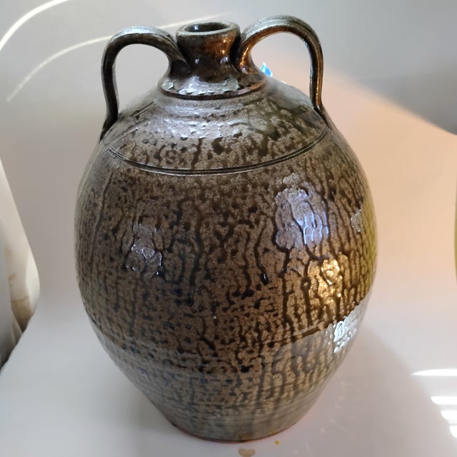 This striking piece is a traditional double-handled folk art stoneware jug created by famed Georgia potter Michael...