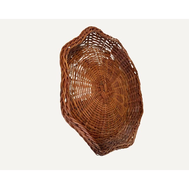 Vintage woven wicker basket with a ruffled, scalloped rim and open weave construction. Tightly coiled base with a warm...