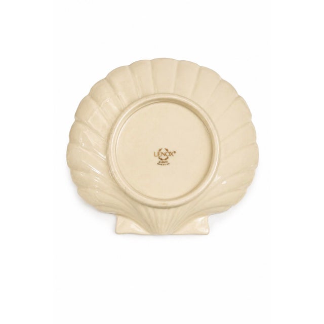 A beautifully sculpted vintage Lenox shell dish featuring soft ivory porcelain with elegant gold trim detailing. The...