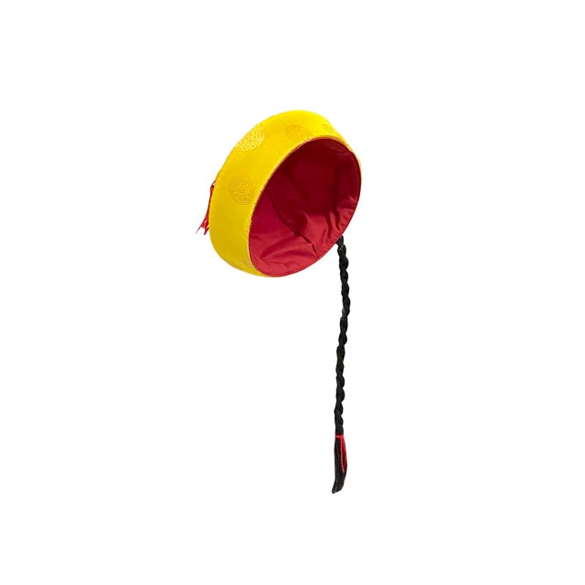 This vibrant yellow satin skullcap captures the traditional aesthetic of a Qing Dynasty-style official’s hat, rendered in...