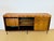 A tall, vintage sideboard in exotic wood, with a modernist scandinavian design from the 1960s-70s, resting on slender...