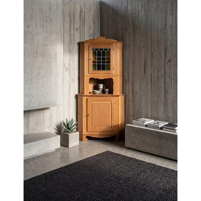 Elegant Danish brutalist corner cabinet from the 1960s, crafted in oak and featuring beautiful leaded glass doors and...