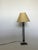 Capture the bold elegance of postmodern design with this striking table lamp, featuring a tall, slender form and an...