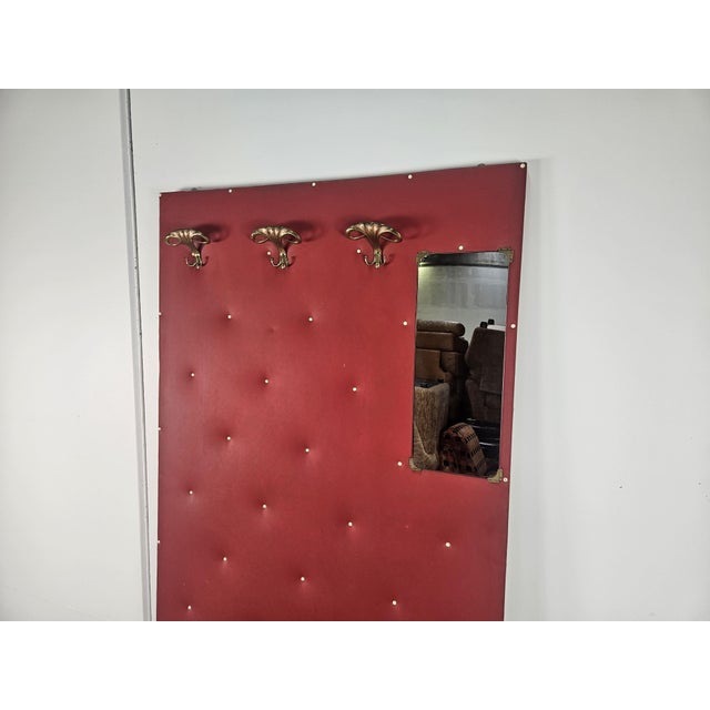 Wall coat hanger in red skai with cream colored lower edge and brass hooks. Enriched by a small side mirror. Very elegant...