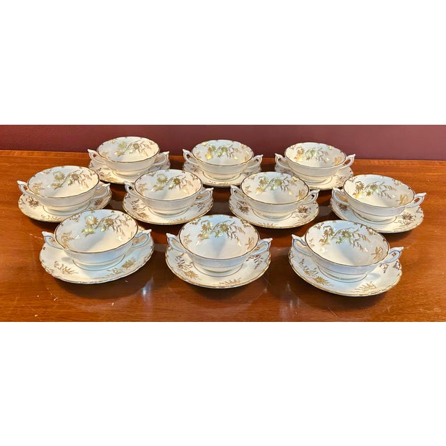 An elegant set of ten Royal Crown Derby “Marquis” Pattern A1222 cream soup bowls with matching underplates, crafted in...