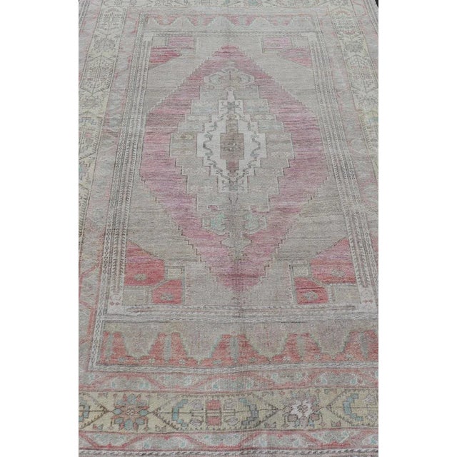 This vintage Turkish Oushak perfectly displays the craftsmanship of this time. The color palette is completely muted, with...