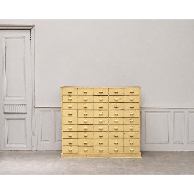 A vintage electrician's cabinet dating from the 1940s, featuring 40 drawers offering ample storage. Its striking, graphic...
