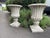 An elegant and highly decorative pair of classical cast stone garden urns, traditionally styled with deeply fluted bodies...