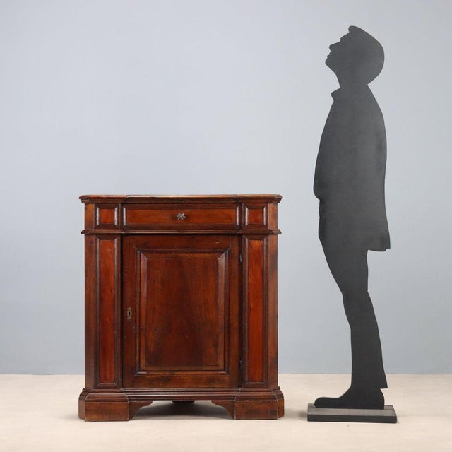 Baroque-style walnut corner cabinet. Drawer in the lower section, paneled door, and bracket legs. Italy, early 20th...