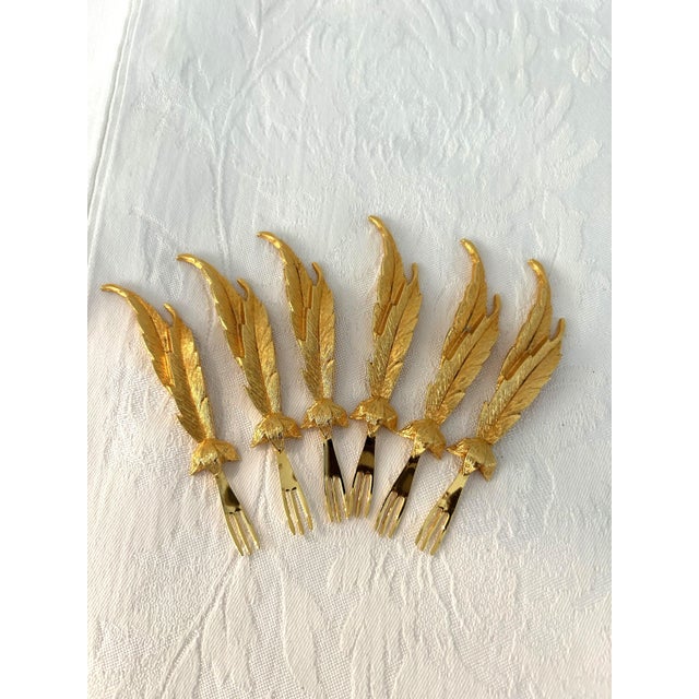 Glamorous set of six mid-century 24 karat gold plated Janis Collection cocktail forks with decorative figural feather...