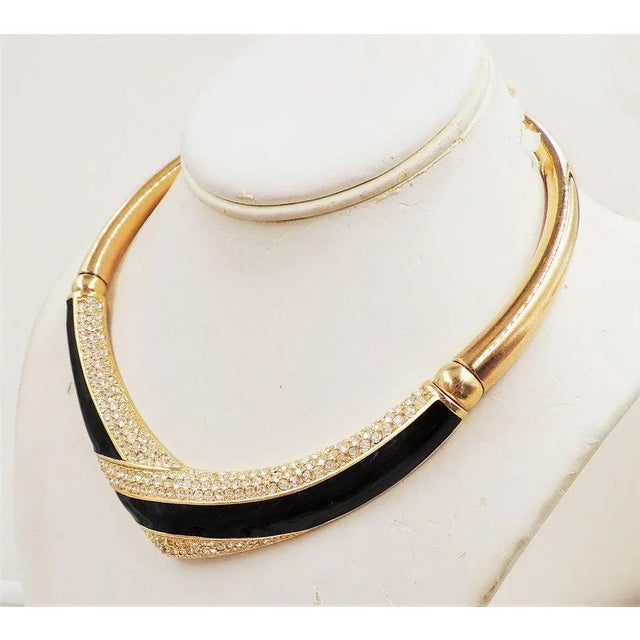 This is part of Chairish’s Costume Jewelry assortment. Goldtone black enamel & Swarovski rhinestones v shaped collar...
