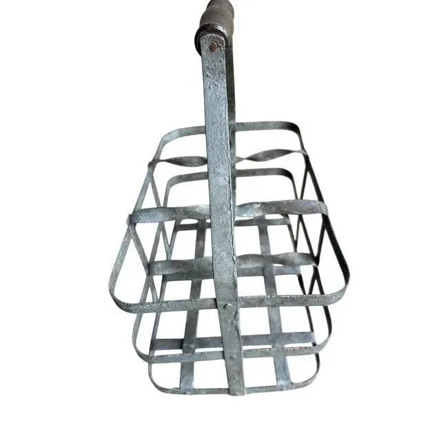 A 1930s French bottle carrier — zinc basket with wood handle, holds 6 bottles. Wine bottles not included. Measures 12"W x...