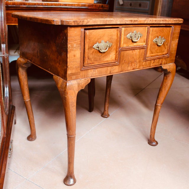 A petite ca. 1710 walnut lowboy with an exceptionally fine top of book matched and highly figured burlwood, further...