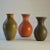 Three Studio Pottery vases in coral red, mat black and moss green are created on the turning wheel by highly technical...