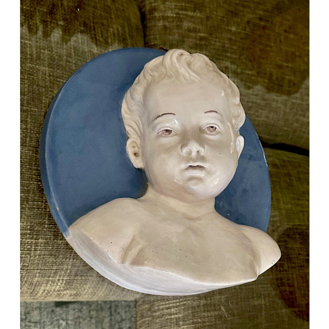 A round Plaque depicting the bust of a young boy in the " Della Robbia" Style from the Italian factory "Cantagalli" dating...