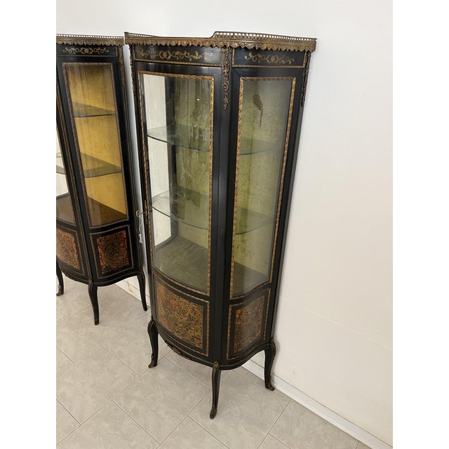 Set of 2 French Boulle display cabinets, 1930s Wood with brass inlays on a red background. Fabric-lined interior, two...