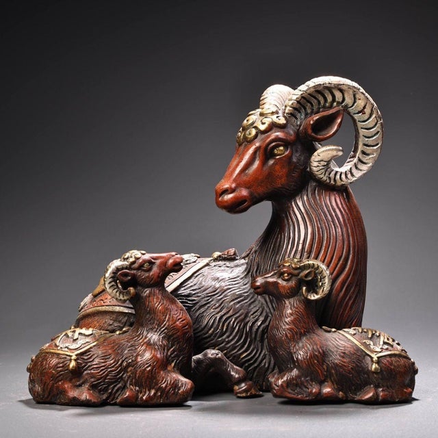 This is a cast bronze figurine featuring a group of three rams, a classic motif symbolizing the arrival of good fortune...