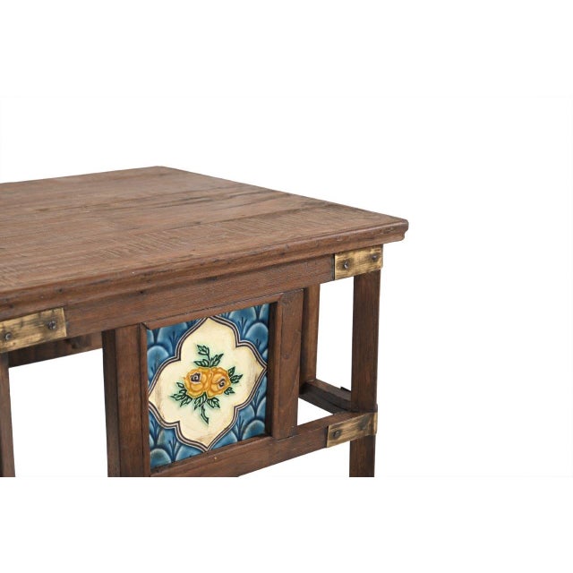 This Vintage Indian Teakwood Side Table is constructed from solid teakwood, featuring decorative ceramic tile insets...