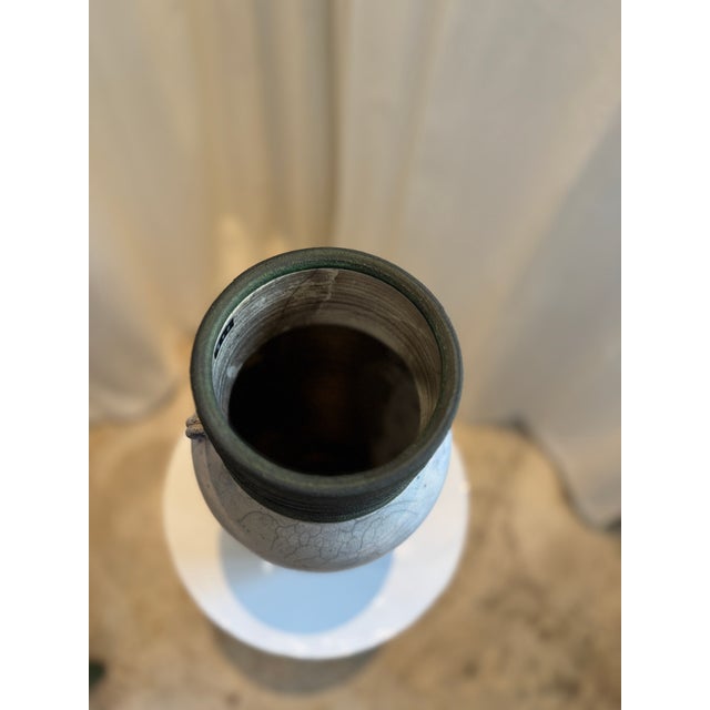 This handcrafted Raku ceramic vase is a captivating blend of traditional artistry and organic texture. The surface...