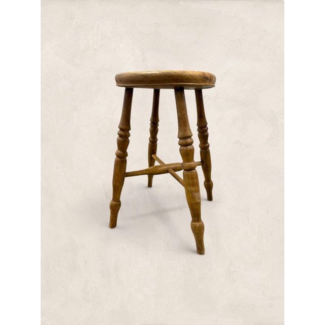 A charming antique English milking stool crafted from solid elm, featuring a beautifully worn circular seat, hand-turned...