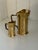 A charming pair of antique brass creamers featuring elegant tapered forms, rolled pouring lips, and angular handles....