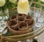 A vintage woven rattan drink-serving set featuring six individual glass holders with integrated coaster bases and a...